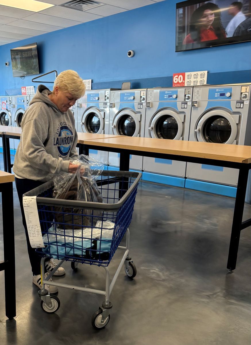 Loads of Clothes Laundry employee bagging freshly washed, dried, and folded clothes for a customer in Donelson and Hermitage TN